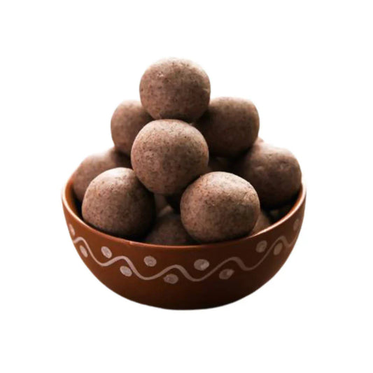 A bowl of millet laddu arranged neatly in a rustic brown bowl. The round, golden-brown laddus have a coarse texture, indicating the use of healthy millet flour mixed with jaggery and ghee. The earthy tone of the bowl complements the natural look of the laddus, making them appear wholesome and nutritious
